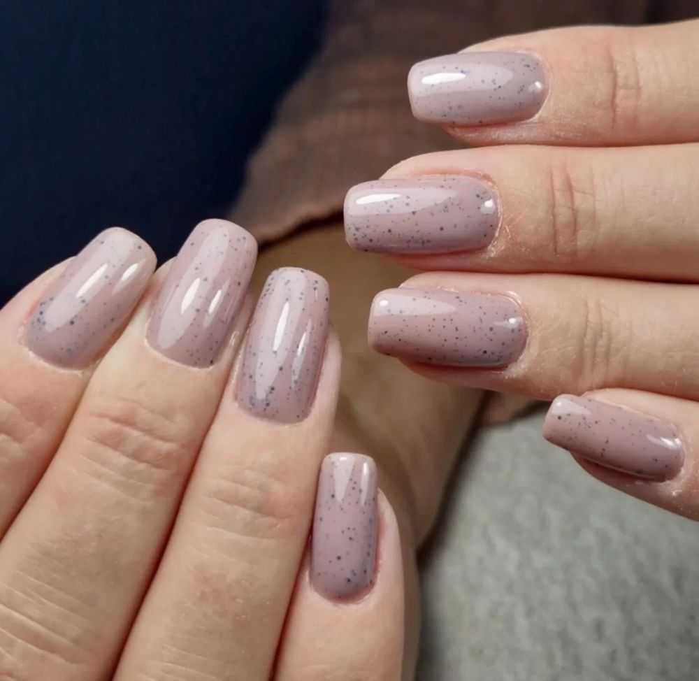 Nude gelakte nagels met zwarte spikkels