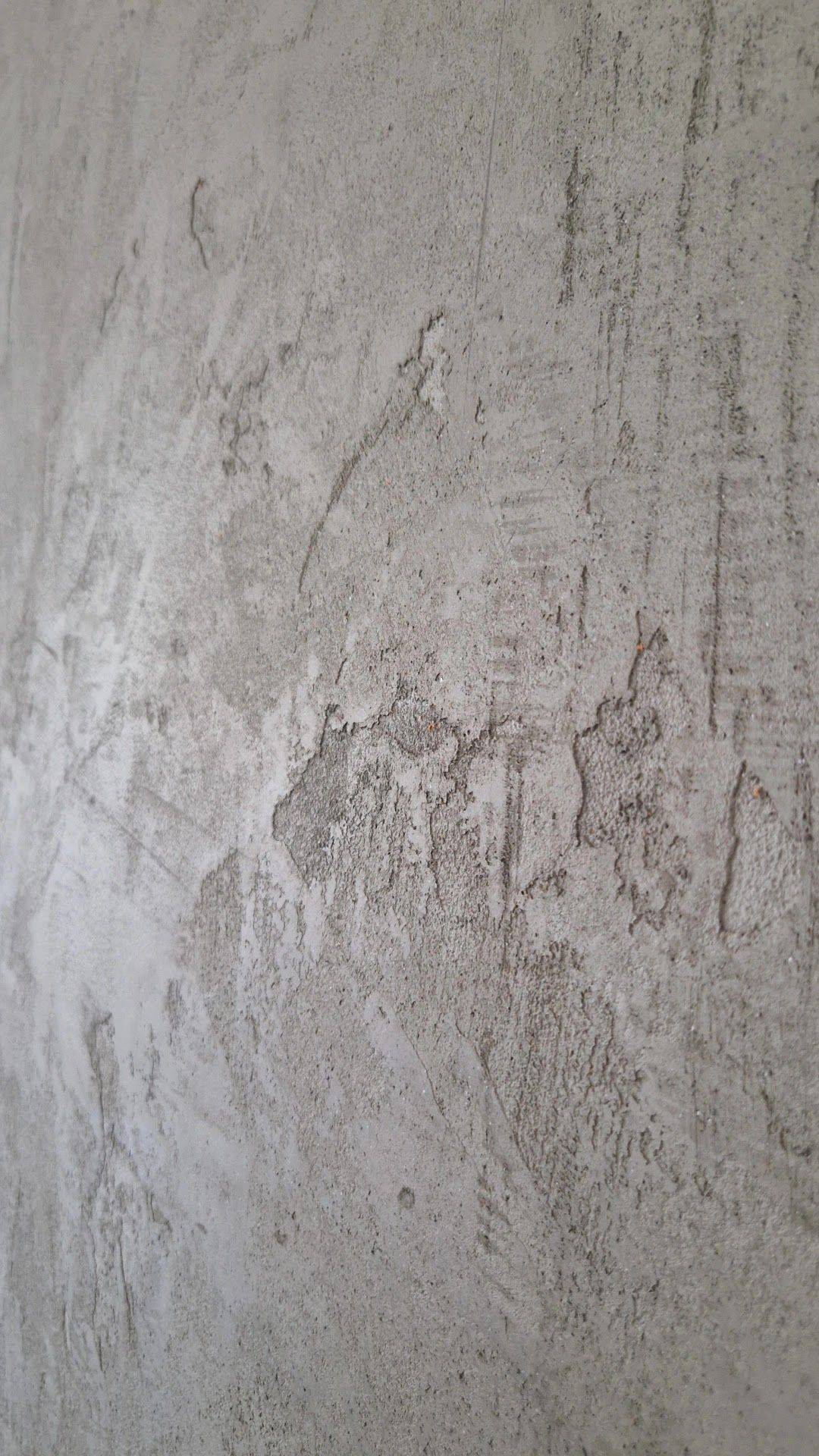 Close-up van een grijze wand in betonlook met zichtbare structuur