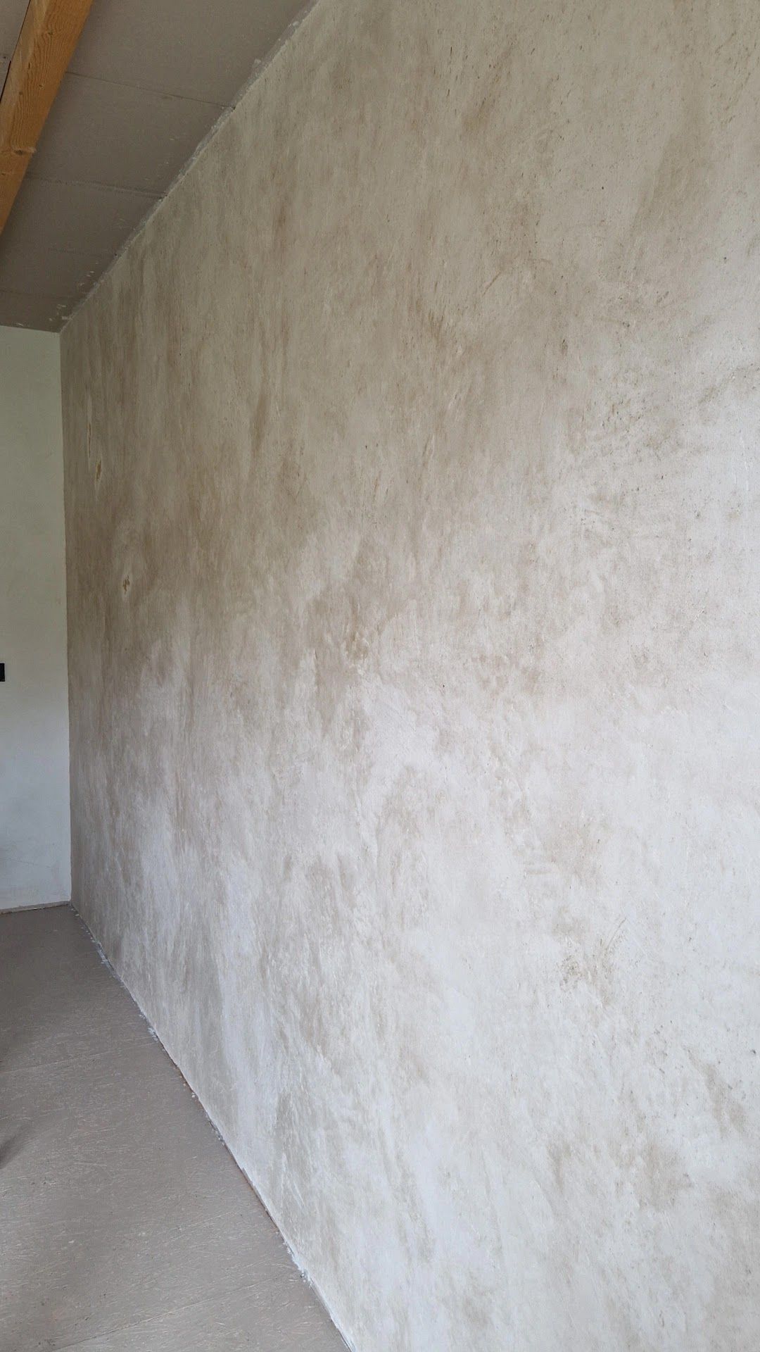 Grote wand in een nieuwbouwhuis, afgewerkt in een lichte zandkleur